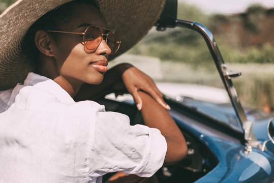 Black Woman Driving A Vintage Convertible Car