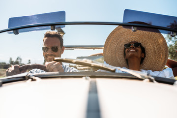 Multiracial couple in a convertible vintage car
