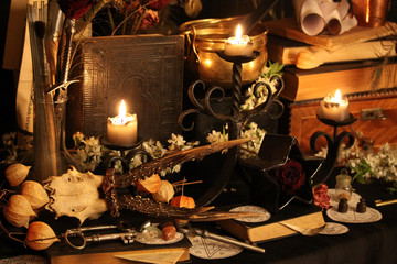 Black candle Magic Ritual. Antique Magic Book. Witchcraft  Peacock feathers and candle background.