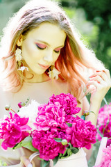 Naklejka premium young woman in the park with flowers