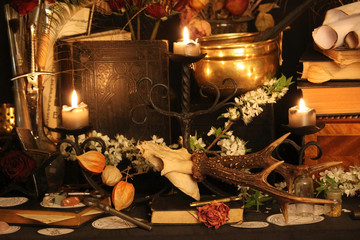 Black candle Magic Ritual. Antique Magic Book. Witchcraft  Peacock feathers and candle background.