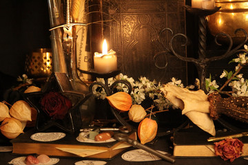 Black candle Magic Ritual. Antique Magic Book. Witchcraft  Peacock feathers and candle background.