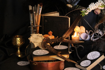 Black candle Magic Ritual. Antique Magic Book. Witchcraft  Peacock feathers and candle background.