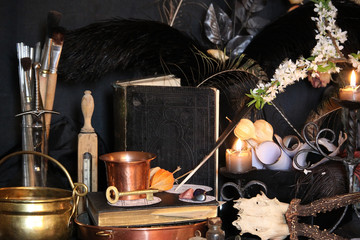 Black candle Magic Ritual. Antique Magic Book. Witchcraft  Peacock feathers and candle background.