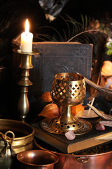 Black candle Magic Ritual. Antique Magic Book. Witchcraft  Peacock feathers and candle background.
