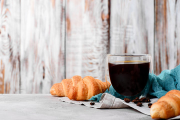 croissants in wooden plates with coffee on a light background