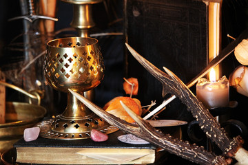Black candle Magic Ritual. Antique Magic Book. Witchcraft  Peacock feathers and candle background.