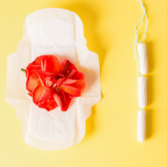 Womans protection in menstruation period. Cotton tampons and pad on the yellow background.