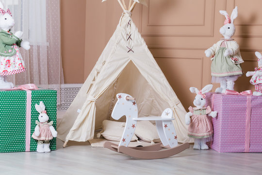 Interior room for a child. Tent for game. Wigwam, toys, rabbits, gifts, rocking horse.