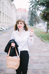 Naklejka na ściany i meble Business Women Style. Woman Going To Work Walking Downstairs. Portrait Of Beautiful Smiling Female In Stylish Office Clothes Going Old Town.