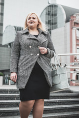 Obraz premium Elegant plump woman at city streets. Concept of people with overweight