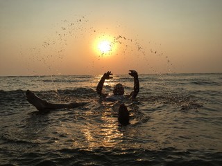 sunset over the sea/man playing like child