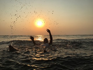 sunset over the sea/man playing like child