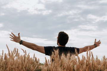 Young man in the wheat field with spread arms   © marjan4782