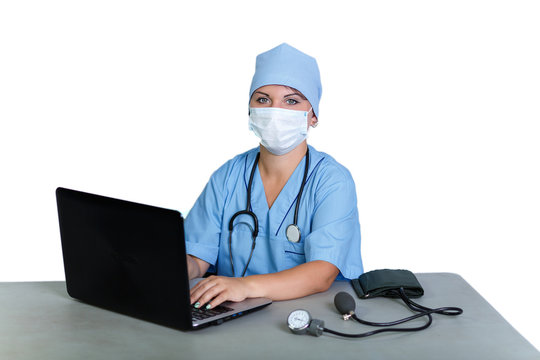 Woman doctor with a stethoscope in a medical mask at the table typing on a computer on a white background.
