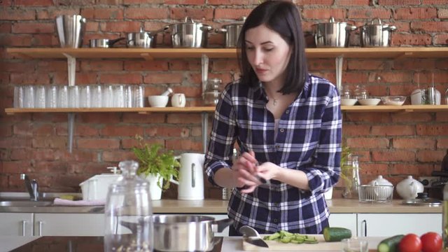 Woman housewife in the kitchen trying spoiled the dish with a spoon out of the pan