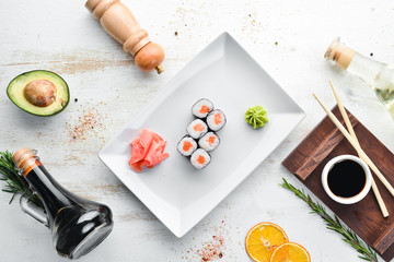 Sushi roll maki with salmon. Japanese cuisine. Top view. On a white wooden background. © Yaruniv-Studio