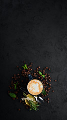Coffee with milk in a cup. Cappuccino. On a black stone background. Top view. Free copy space.