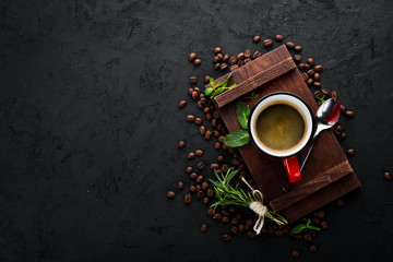 Black coffee in a cup. On a black stone background. Top view. Free copy space.
