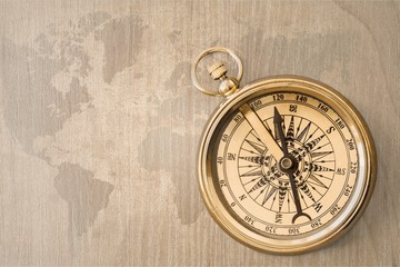 Fototapeta na wymiar Brass antique compass on wooden background