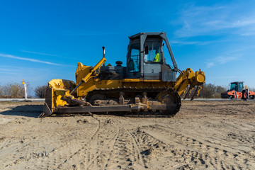 Fototapeta premium big bulldozer aligns ground for asphalt