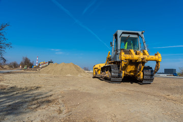 big bulldozer aligns ground for asphalt