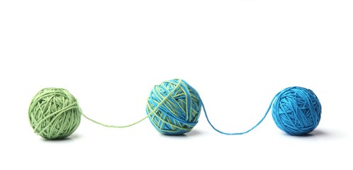 Colorful cotton thread balls from two color green and blue thread isolated on white background....