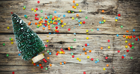 Christmas concept background decorative christmas tree on old wooden background with colorful confetti with copy space