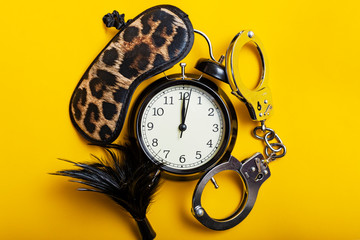 Sex time concept. Black alarm clock with sex toys.