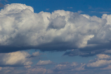 Fototapeta na wymiar Large white cumulus clouds in the blue sky