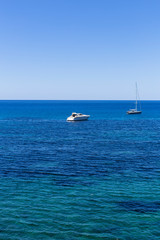 Obraz premium beautiful landscape in Ibiza of blue ocean in a sunny day with boats in the horizon. Summer and holidays concept.