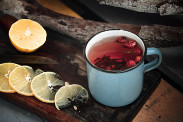 tea with lemons in a rustic forest style on wooden background with old knife and wooden cutting Board