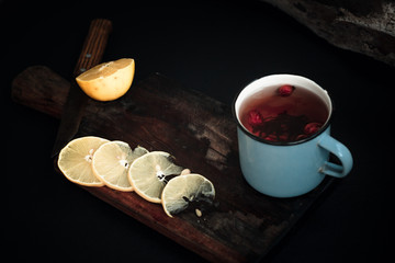 tea with lemons in a rustic forest style on wooden background with old knife and wooden cutting Board