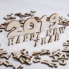 Congratulations with new 2019 year made of wooden letters on a light background