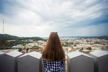 Fototapeta na wymiar Tourist girl on top of european city hall with sky