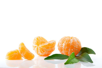 Ripe and juicy mandarin with green leaves close-up