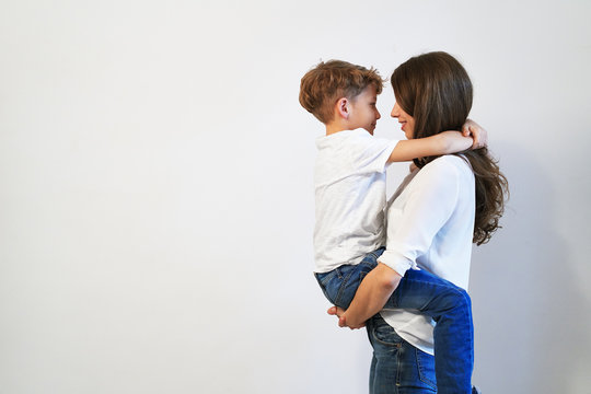  mother holding her preteen son smiling and looking into his eye