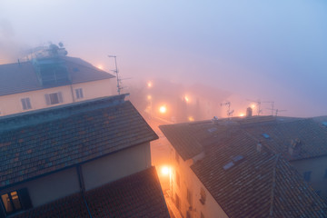 High angle, aerial view on foggy misty weather, fog, mist in morning with houses, buildings, roofs,...