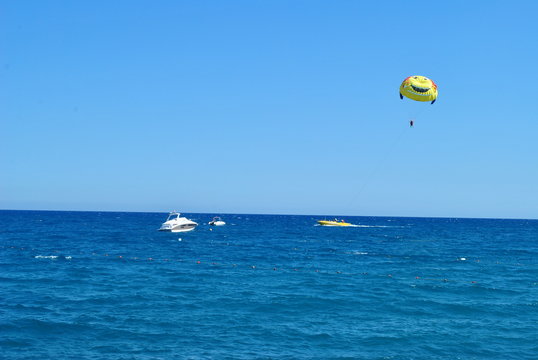 parachute, sea, sport, sky, water, beach, parasailing, ocean, flying, blue, fly, kite, wind, boat, fun, summer, extreme, paragliding, sports, surf, surfing, parasail, travel, kiteboarding, air