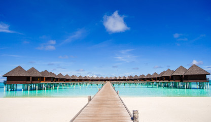 Fototapeta na wymiar Water bungalows and wooden jetty on Maldives