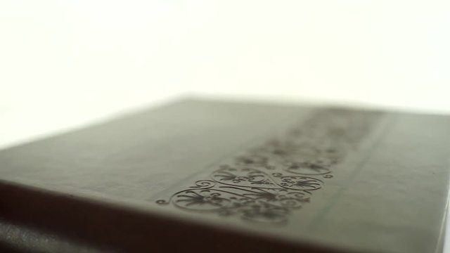 Photo album in leather cover rotates on a white background.