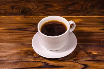Cup of dark coffee on wooden table