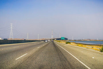 Travelling on Dumbarton bridge towards east San Francisco bay area; smoke and pollution in the air from nearby wildfires; Silicon Valley, California