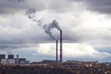 Fototapeta premium Urban cloudy landscape. Citypipes fuming an industrial area illustrating pollution and production harm