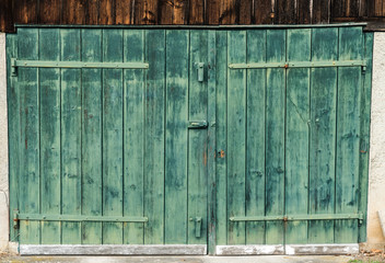 close up view of an old vintage rustic green wooden barn door on a wooden shed