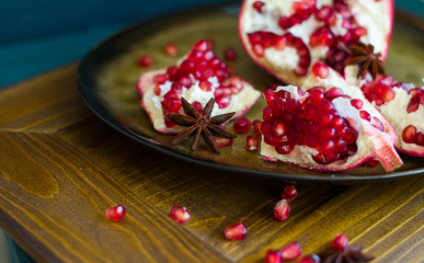 pomegranate lies on a plate, pomegranate seeds (close up)