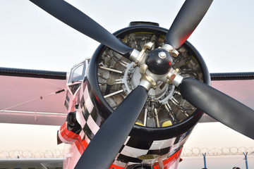 Piston engine and propeller of a vintage biplane in sunset light, closeup