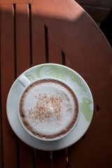 Closeup of A cup of Latte Art hot coffee over wooden  table top background in coffee's shop