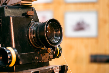 Photo of an old movie camera on a wooden background in a film studio.