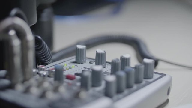 Sound engineer / Producer / musician rotates a knob of a sound mixer in the studio